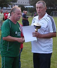 Staffelleiter Gerd Simmang überreicht Radebeuls Kapitän Rainer Adam den Pokal.