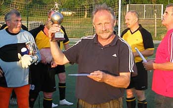 Rainer Adam schwengt stolz den Meisterpokal.