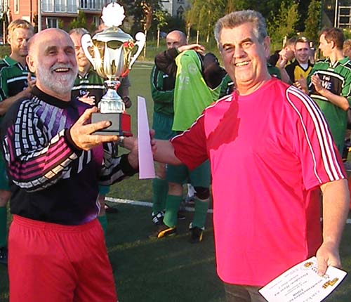 Staffelleiter Gerd Breiter übergibt den Pokal an Weixdorfs Kapitän.