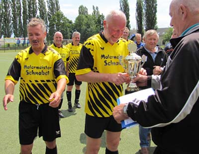Der Radeberger Kapitän Bernhard Täuber empfängt den Pokal.