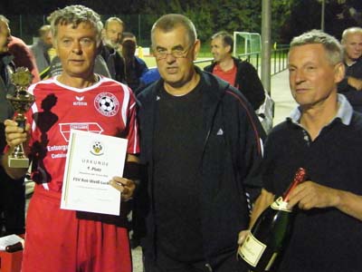 Gerd Breiter und Turnierleiter Peter Schubert gratulieren dem Kapitän des FSV Rot-Weiß Luckau.