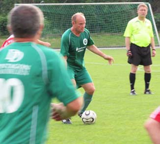 Holger Dörwald führt den Ball. Schiedsrichter Thomas Ockert beobachtet ihn dabei.
