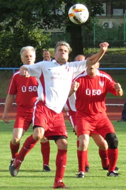 Peter Fritzsche und Peter Pordzik beobachten, wie Ralf Pagels den Ball annimmt.